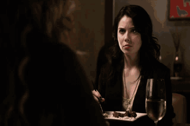 a woman sitting at a table with a plate of food