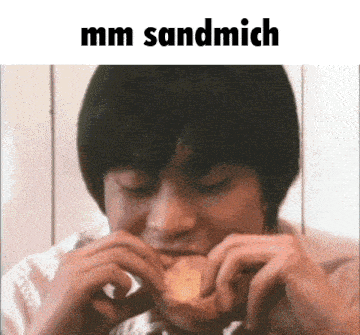 a man is eating a sandwich with the words mm sandwich written above him