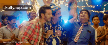 a group of men are dancing at a party with the website kulfyapp.com visible in the corner