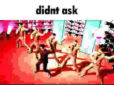 a group of naked people are dancing on a red carpet on a stage .