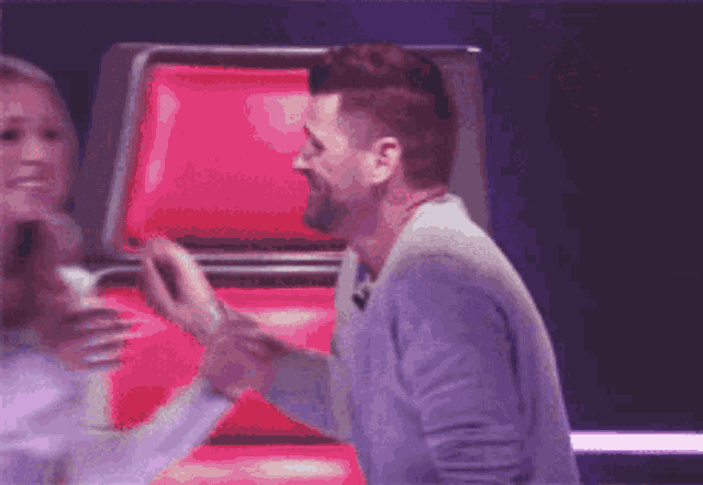 a man and a woman are hugging each other in front of a red chair .