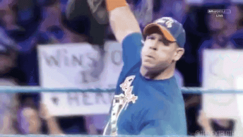 a man in a wrestling ring with a sign in the background that says win