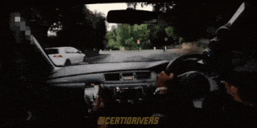 a man is driving a car with a phone in his hand