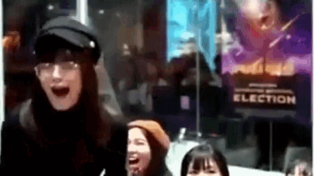 a group of people are laughing in front of a election poster