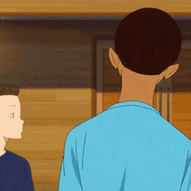a man in a blue shirt is standing next to another man .