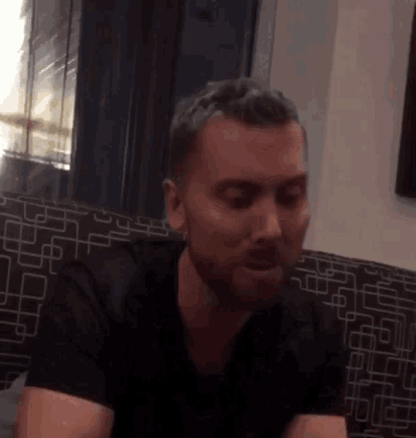 a man with a beard is sitting on a couch