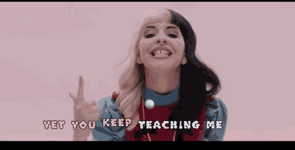 a woman is making a funny face and pointing at the camera .