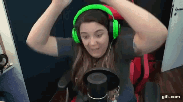 a woman wearing green headphones is sitting in a red chair .