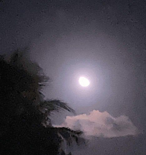 a full moon shines brightly in a cloudy sky