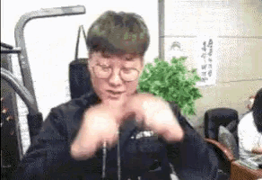 a man wearing glasses is sitting in a chair