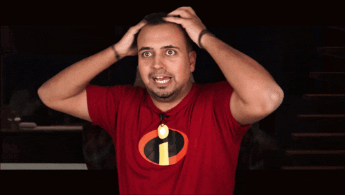 a man wearing a red shirt with an i on it holds his head