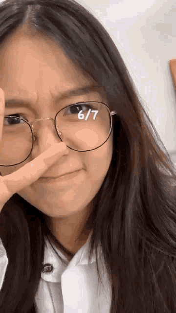 a girl wearing glasses with the number 6/7 on her eye