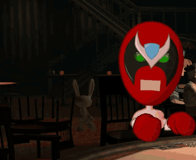 a cartoon character wearing a red mask with green eyes is sitting at a table in a dark room
