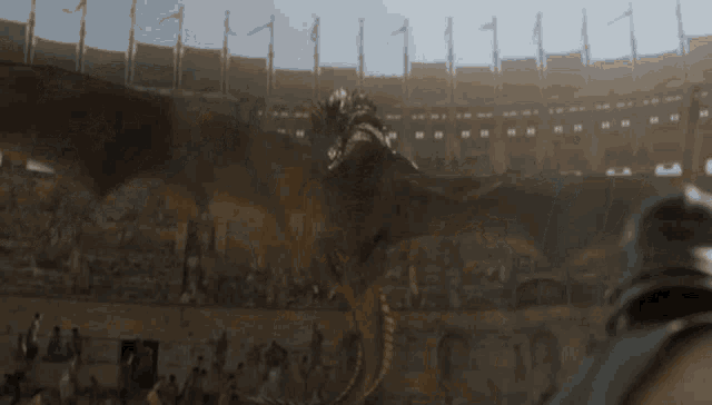 a dragon is flying through the air in a stadium with people watching