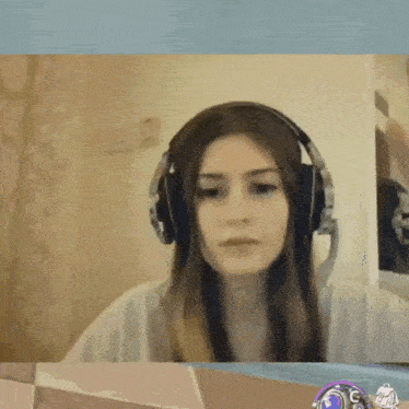 a woman wearing headphones and a microphone is sitting in front of a laptop .