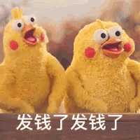 two stuffed chickens are sitting next to each other with chinese writing on the bottom right