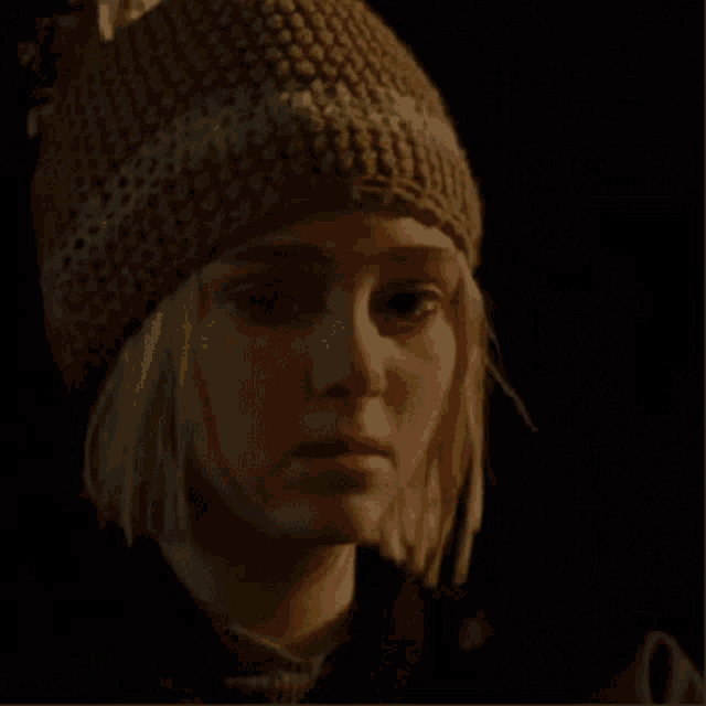 a woman wearing a knitted hat is crying