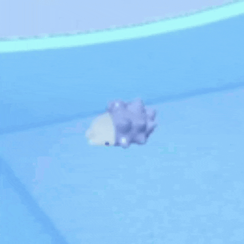 a purple and white toy is floating on top of a blue surface .