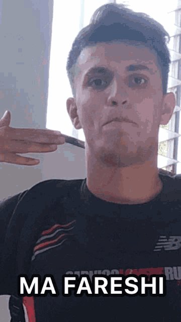 a man wearing a black shirt with the word ma fareshi on it