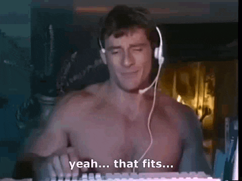 a shirtless man is wearing headphones and playing a keyboard .