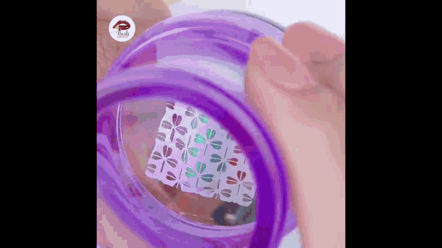 a person is holding a purple object with a pattern on it .