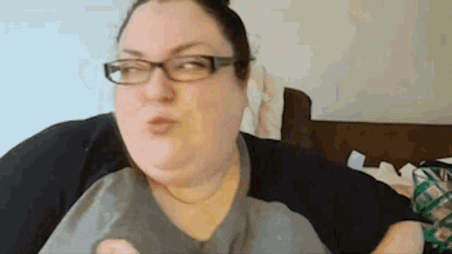 a woman wearing glasses is sitting on a couch .