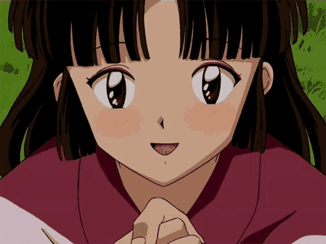a close up of a girl 's face with her hands folded in front of her face
