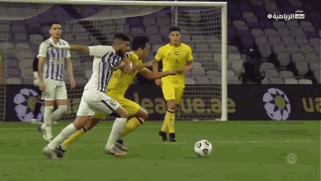 a soccer game is being played in a stadium with a banner that says league ae