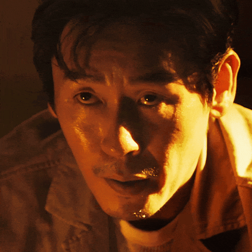 a close up of a man 's face with a yellow shirt