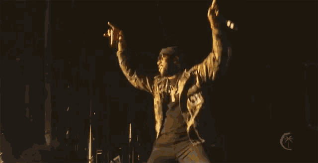 a man in a camouflage jacket is giving the middle finger in the dark