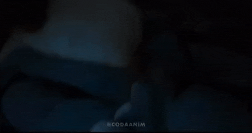 a close up of a person giving the middle finger in the dark .