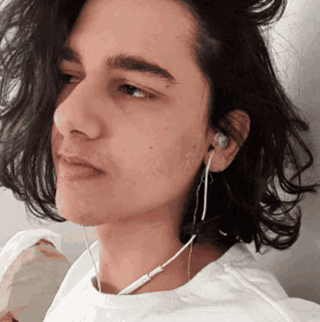 a young man wearing headphones and a white t-shirt