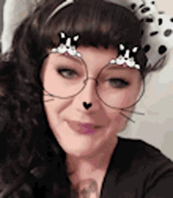a woman wearing a dalmatian hat and glasses with a cat face filter on her face .