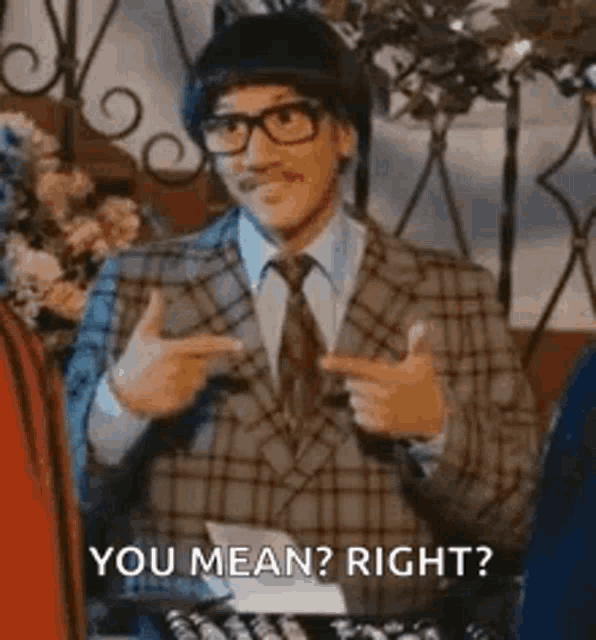 a man in a suit and tie is pointing at himself and saying `` you mean right ? ''