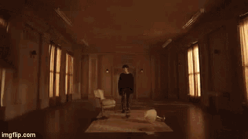 a man is standing in a room with a large explosion coming from the ceiling .