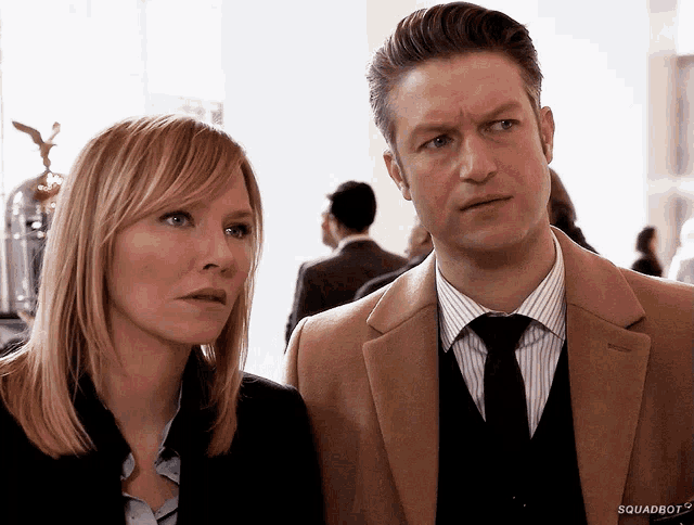 a man and a woman are standing next to each other and the man 's jacket says squadron