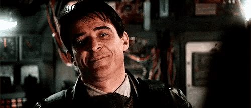 a man in a suit and tie is smiling while standing in a room .