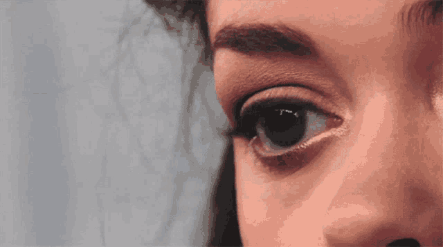 a close up of a woman 's eye with a blue eye
