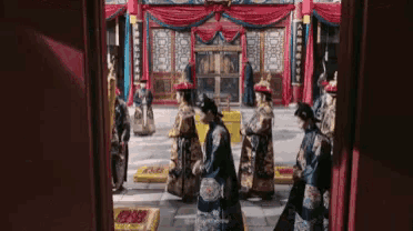 a group of people in traditional chinese costumes are walking in a line .