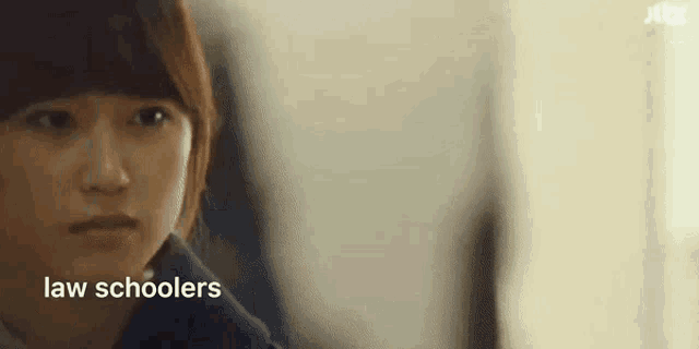 a close up of a woman 's face with the words law schoolers written on it .