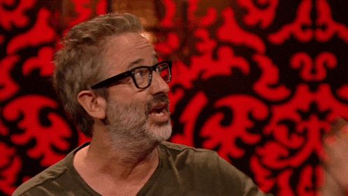 a man with glasses and a beard is making a face