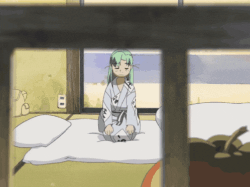 a girl with green hair sits on a bed