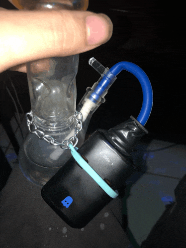 a person is holding a bong with a blue hose connected to it