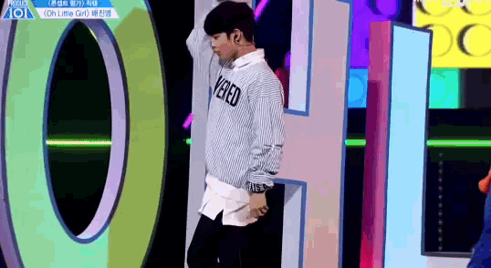 a man wearing a sweater that says vered on it is dancing on a stage