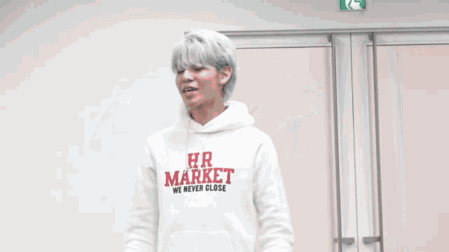 a man wearing a white hoodie that says hr market on it