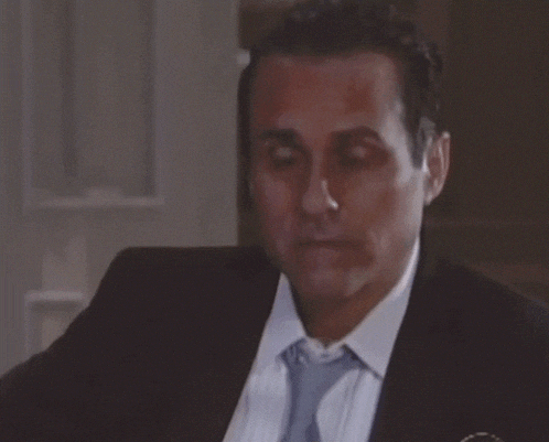 a man in a suit and tie is looking down with his eyes closed