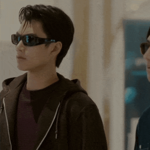 a man wearing sunglasses and a hooded jacket