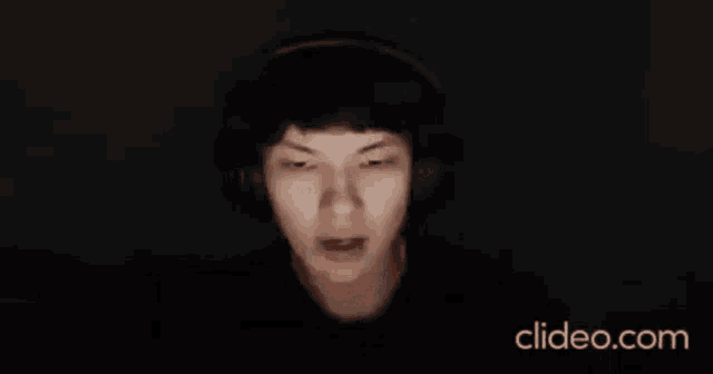 a man wearing headphones is making a face in the dark .