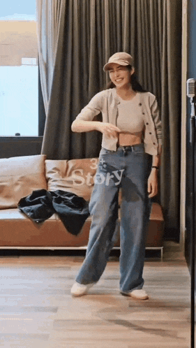 a woman is standing in front of a couch in a room .