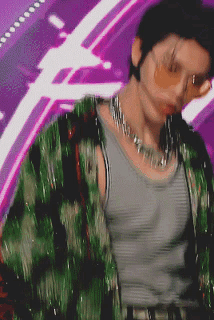 a blurry picture of a man wearing sunglasses and a green jacket
